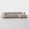 A modern beige sectional sofa with clean lines and a wooden base, set against a plain white background. The sofa has three seats and an extended chaise lounge on the right side.