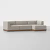 A modern beige sectional sofa with clean lines and a wooden base, set against a plain white background. The sofa has three seats and an extended chaise lounge on the right side.