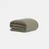 A neatly folded, olive green comforter or blanket is displayed against a plain white background.