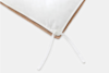 A close-up of a pillow with a white cover, showing a corner with fabric ties and a brown inner layer visible underneath. The ties are resting on a light gray surface.