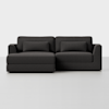 A modern dark gray sectional sofa with a left-facing chaise lounge and two rectangular back cushions, set against a plain white background.