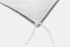 Close-up of the corner of a white comforter showing a white fabric tie, with gray fabric edging visible underneath, against a plain white background.