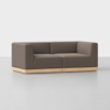 A modern, boxy brown sofa with angular armrests and a low wooden base, set against a plain white background.