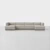 A modern, light beige modular sectional sofa with clean lines and low backrests is arranged in a spacious, minimalist room with a light gray floor and a white background.