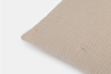 A close-up of a beige pillow with a textured, crinkled fabric cover, shown against a plain white background.
