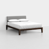 A modern bed with a dark wooden frame, gray upholstered headboard, and white bedding with two pillows, set against a plain white wall and light-colored floor.