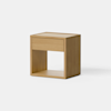 A minimalist wooden nightstand with a single drawer and an open shelf at the bottom, set against a plain white background.