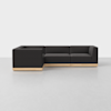 A modern, L-shaped sectional sofa with dark gray upholstery and a light wooden base, placed on a light gray floor against a plain white background.
