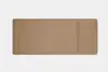 A rectangular, tan leather desk pad with rounded corners and a stitched border, featuring a smaller, attached section on the right side. The background is plain white.