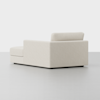 A modern, minimalist sectional sofa in an off-white fabric is shown on a light gray floor, viewed from the back and slightly to the side. The sofa has clean lines and a low profile.