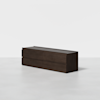 A modern, dark wood dresser with six drawers is placed on a light, plain floor against a white background. The dresser has a minimalist, rectangular design without visible handles.