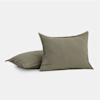 Two olive green square pillows are shown, one upright and one lying flat, against a plain white background.
