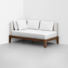 A modern daybed with a wooden frame, white upholstered backrest, and four white cushions, placed against a white wall in a minimal, empty room.
