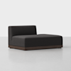 A modern, dark gray chaise lounge with a low, solid wood base and a single backrest on the left side, set against a plain light background.