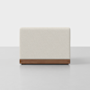 A modern, rectangular cream-colored upholstered bench with a wooden base, photographed against a plain white background.