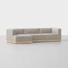 A modern, light gray L-shaped sectional sofa with a low wooden base, set against a plain white background.
