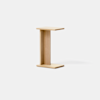 Minimalist wooden side table with a light natural finish, designed in the shape of a capital I with flat top and bottom surfaces connected by a vertical panel. The background is plain and white.