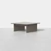 A square, modern coffee table made of wood with a smooth, flat top and thick, rectangular legs, displayed on a light gray surface against a plain white background.
