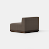 A modern armless brown upholstered chair with a boxy shape and a dark wooden base, shown angled against a plain white background.