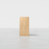 A light wood dresser with four drawers, viewed from the side against a plain white background. The design is minimalist and modern.
