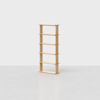 A simple, light wood bookshelf with five shelves standing on a plain, light gray floor against a white background.