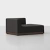 A modern, low-profile black upholstered chaise lounge with a right-angle back and armrest on a dark wooden base, set against a plain white background.