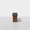 A modern bench with a wooden base and a black cushioned seat, placed in a minimalistic, light-colored room with a plain white background.
