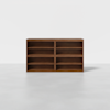 A wooden bookshelf with a medium-brown finish, featuring two sections side by side, each with three adjustable shelves, standing on a plain light gray floor against a white background.