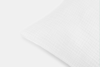 A close-up of a white pillow with a subtle textured, grid-like pattern on its fabric, set against a plain white background.