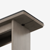 Close-up view of the underside of a wooden table, focusing on the corner where the tabletop meets the leg. The table has smooth, rounded edges and a light wood finish.