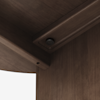 Close-up view of the underside corner of a wooden table, showing the joinery and a black metal fastener securing two pieces together, with smooth brown wood grain visible.