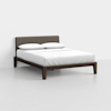 A modern bed with a dark wooden frame, a cushioned fabric headboard in gray, and white bedding with two pillows, set against a plain white background.