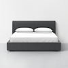 A modern platform bed with a dark gray upholstered frame and headboard, neatly made with white bedding and two white pillows, set against a plain white wall and light gray floor.