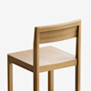 A simple wooden chair with a straight backrest and square seat, shown at an angle against a plain white background.
