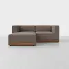 A modern L-shaped sectional sofa with brown upholstery and a wooden base, set on a light gray floor against a plain white background.