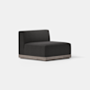 A modern, armless lounge chair with dark charcoal upholstery and a low, light wood base, set against a plain white background.