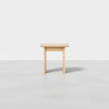 A simple, light wood stool with a square top and four straight legs, placed on a plain, light gray surface against a white background.