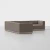 A modern, L-shaped sectional sofa upholstered in brown fabric with a low back and deep seats, set against a plain white background on a smooth, light-colored floor.