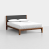 A modern wooden bed frame with a dark gray upholstered headboard, dressed with white bedding and two pillows, set against a plain white background.