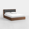 A modern wooden bed frame with a dark gray upholstered headboard, dressed in white bedding and two pillows, set against a plain white background.