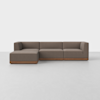 A modern, L-shaped sectional sofa with brown upholstery and a wooden base, set against a plain white background on a light-colored floor.