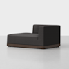 A modern, dark gray upholstered chaise lounge with a low wooden base and a right-sided backrest, set on a light gray floor against a plain white background.