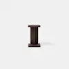 A small, dark wooden side table with a square top and base, and a central rectangular support, placed on a plain light gray surface against a white background.