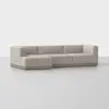 A modern, light beige sectional sofa with a low-profile, L-shaped design and wooden base, set against a plain white background.