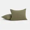 Two olive green textured pillows are placed on a light gray surface; one pillow is lying flat while the other is propped upright in front of it.