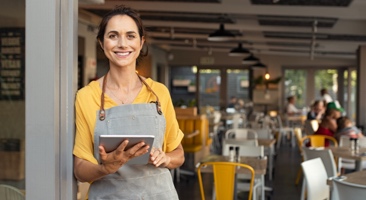 Image of a store owner in front of her restaurant