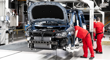 two people working on car at an automobile manufacturer