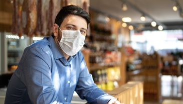 Store owner in a retail store with a face mask