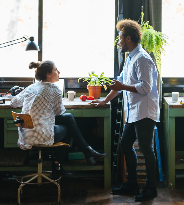 Two Constant Contact customers talking by a desk.