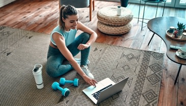 woman working out on the floor next to her computer